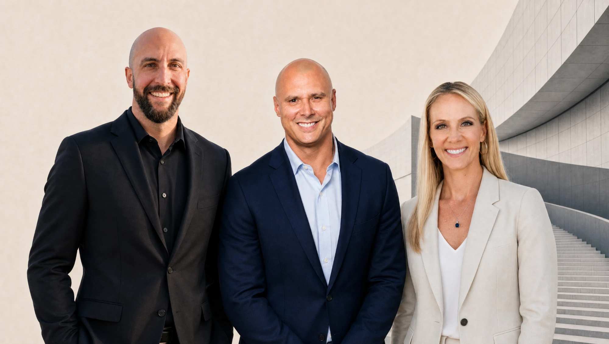 The three SN3 Group founders — John Lipe, Alex Mont-Ros, and Lisa Mont-Ros — standing together against a sweep of curved architecture and stairs